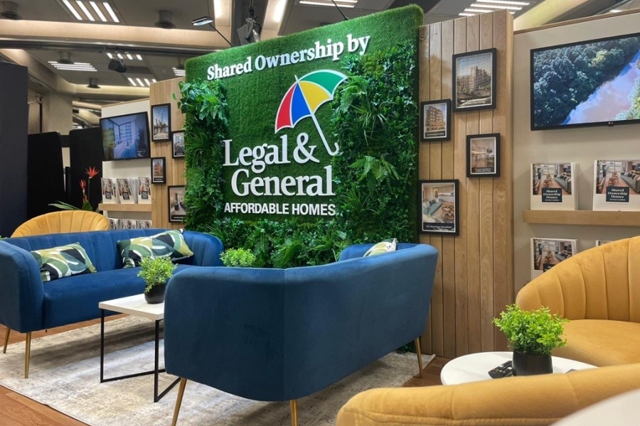 Seating area with two blue sofas and a backdrop with artificial plants coming off of it