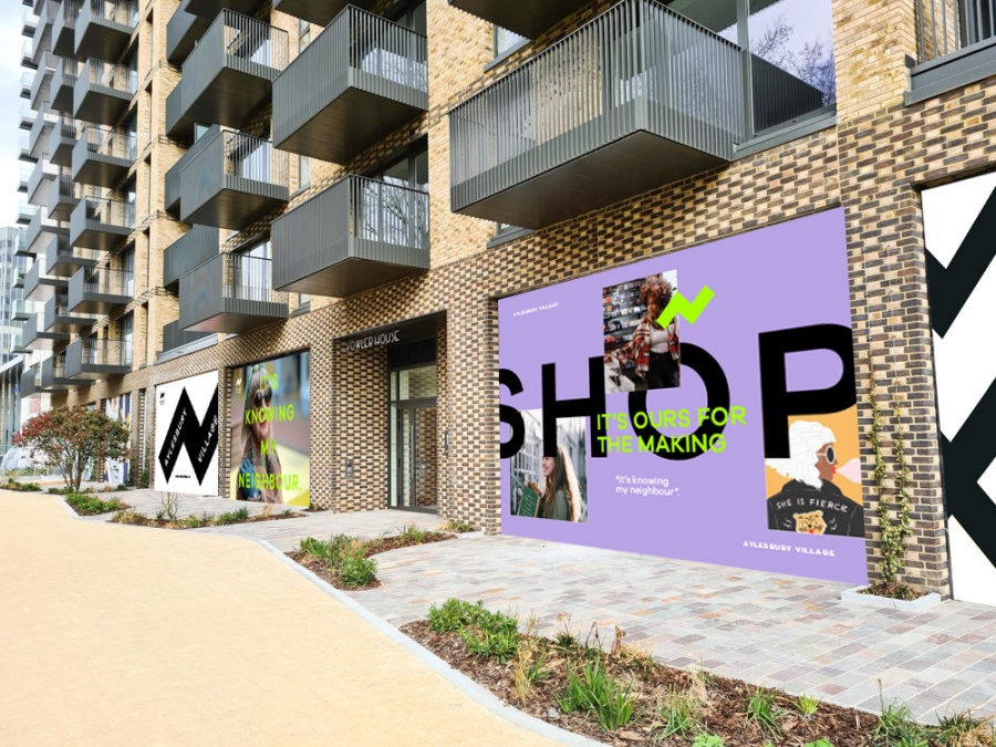 A large modern apartment complex with lots of individual balcony's and marketing campaign posters on the ground floor windows