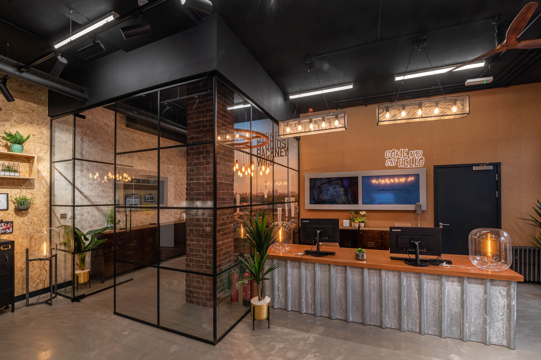 Reception desk with two computers and a meeting room to the left of it