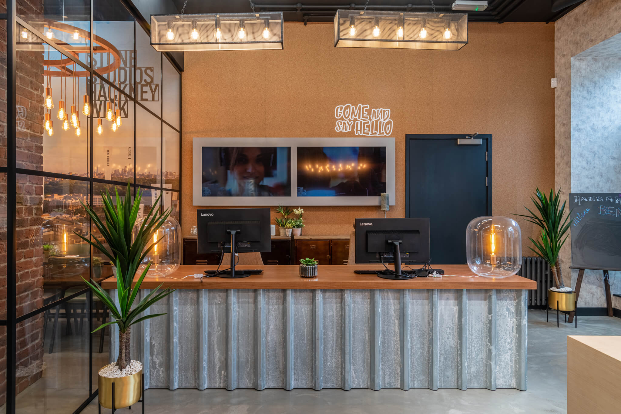 Reception desk with two computers and a meeting room to the left of it