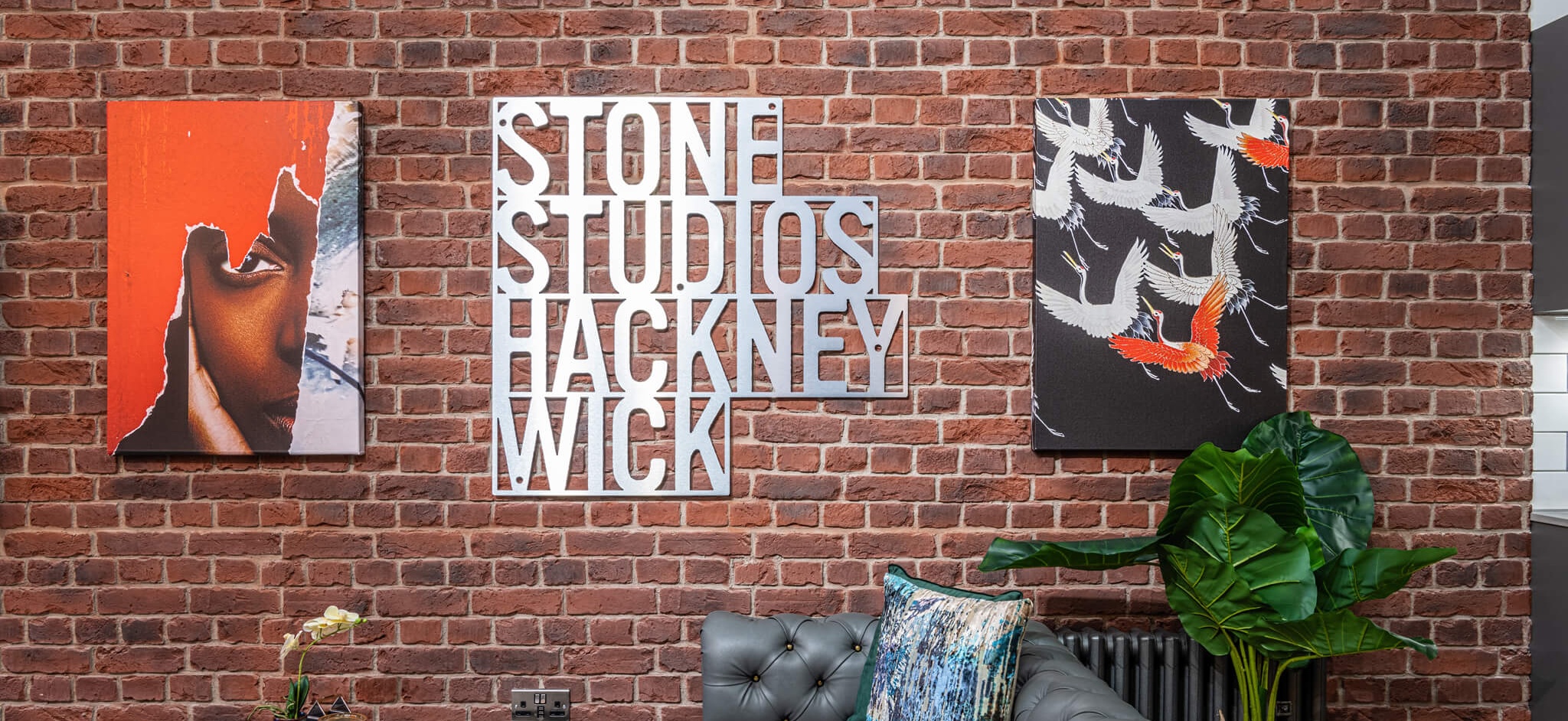 Brick wall with artwork on it and a sign