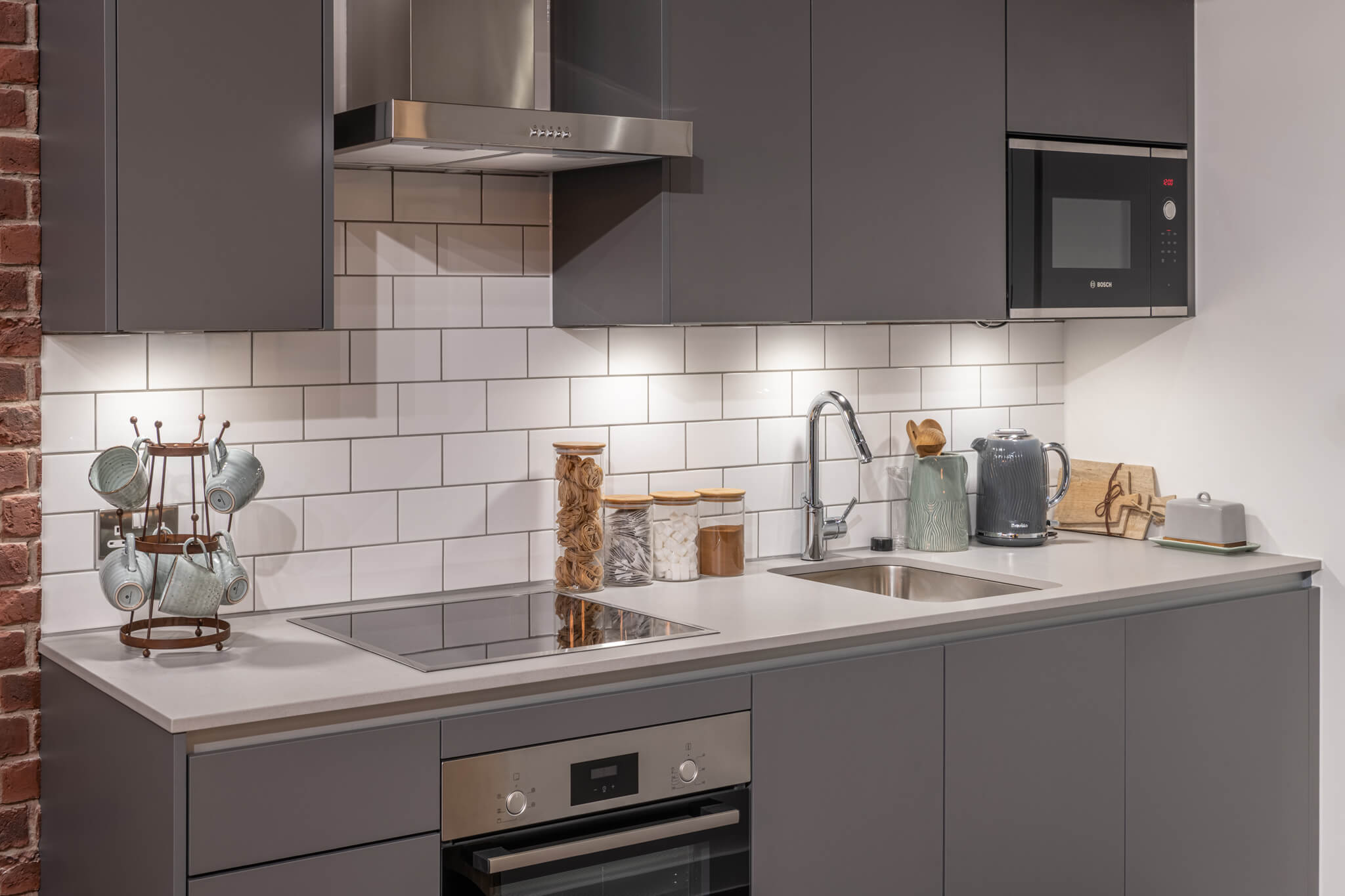 Kitchen with grey cabinets and a white tiled backsplash