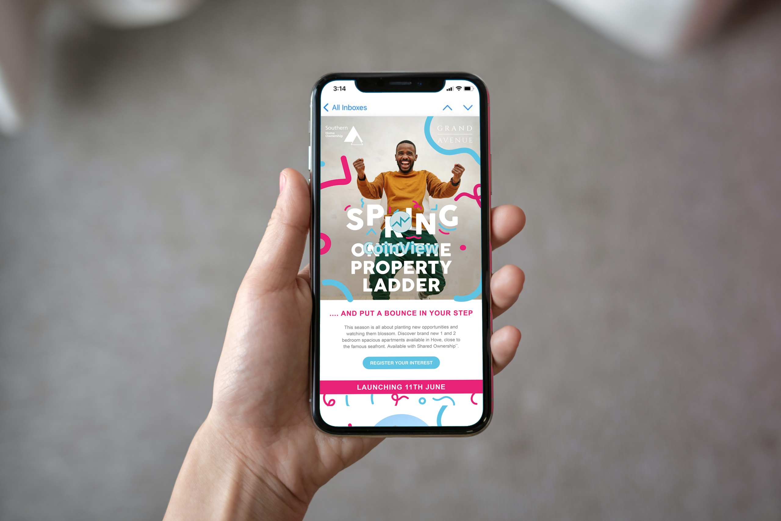 Hand holding a phone with a bright email marketing campaign on the screen