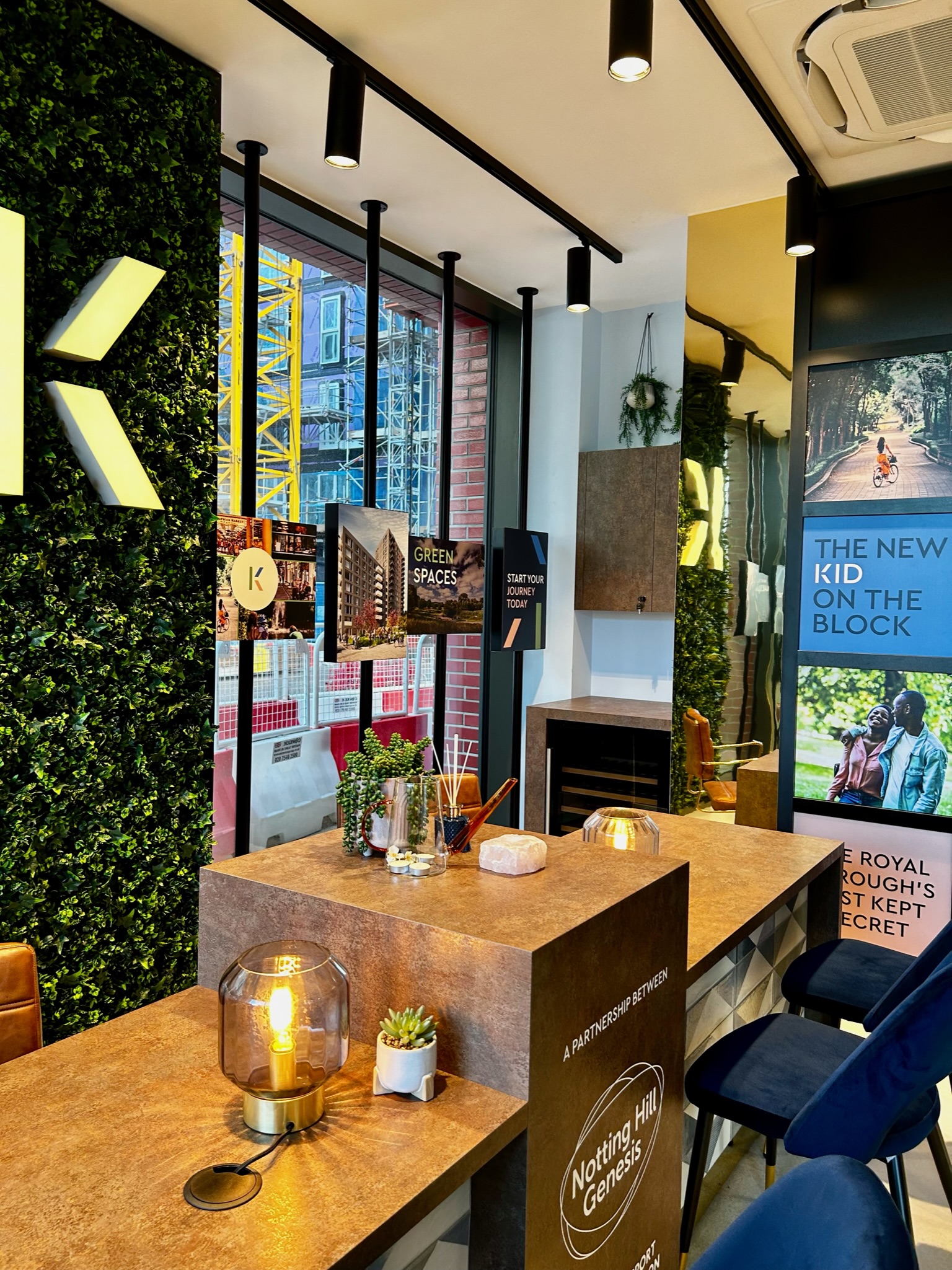 marketing suite with two desks that are holing multiple decorations such as plants and lamps
