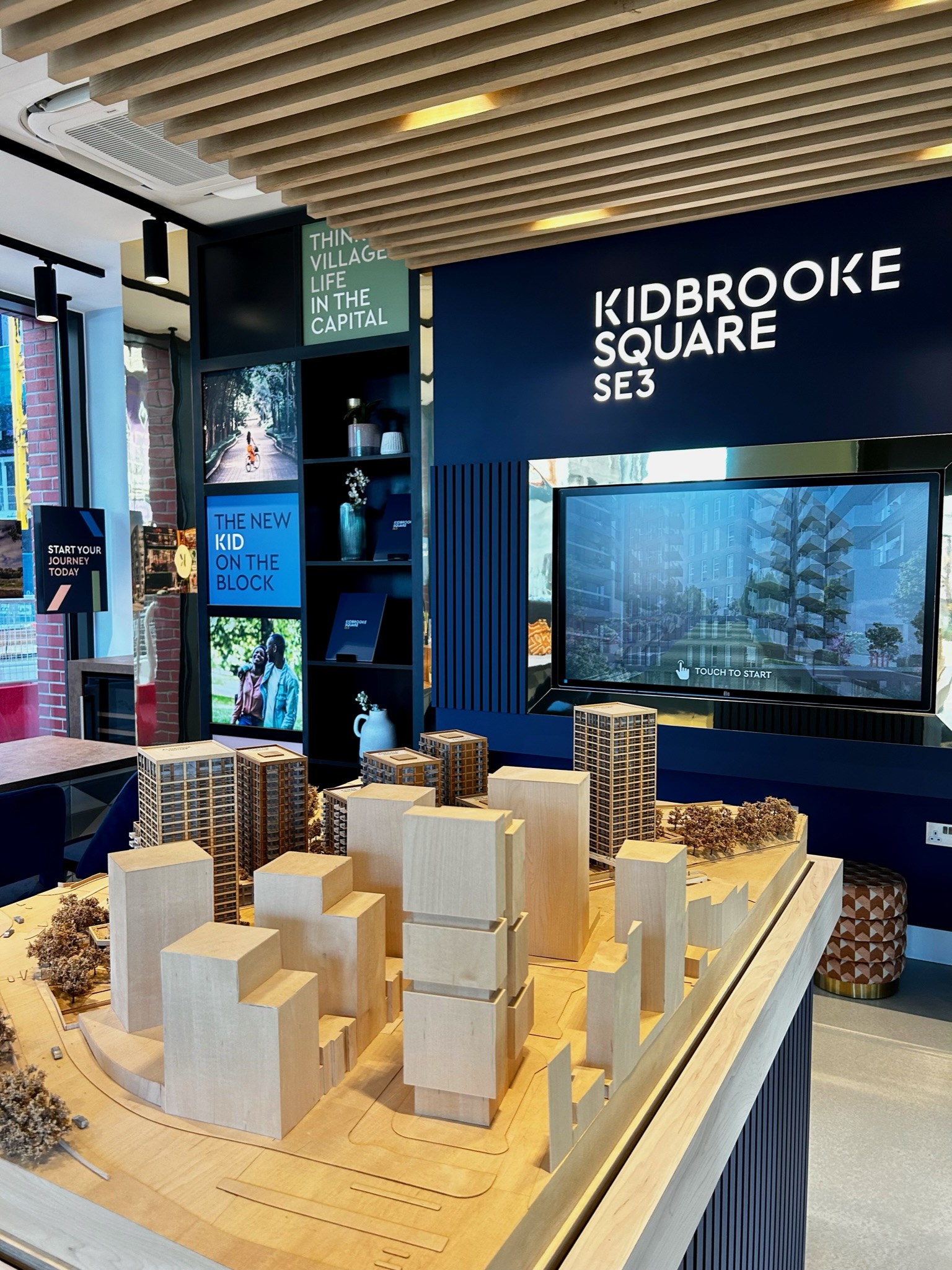 marketing suite with a large 3D model of the city around the development and a TV that showcases the development