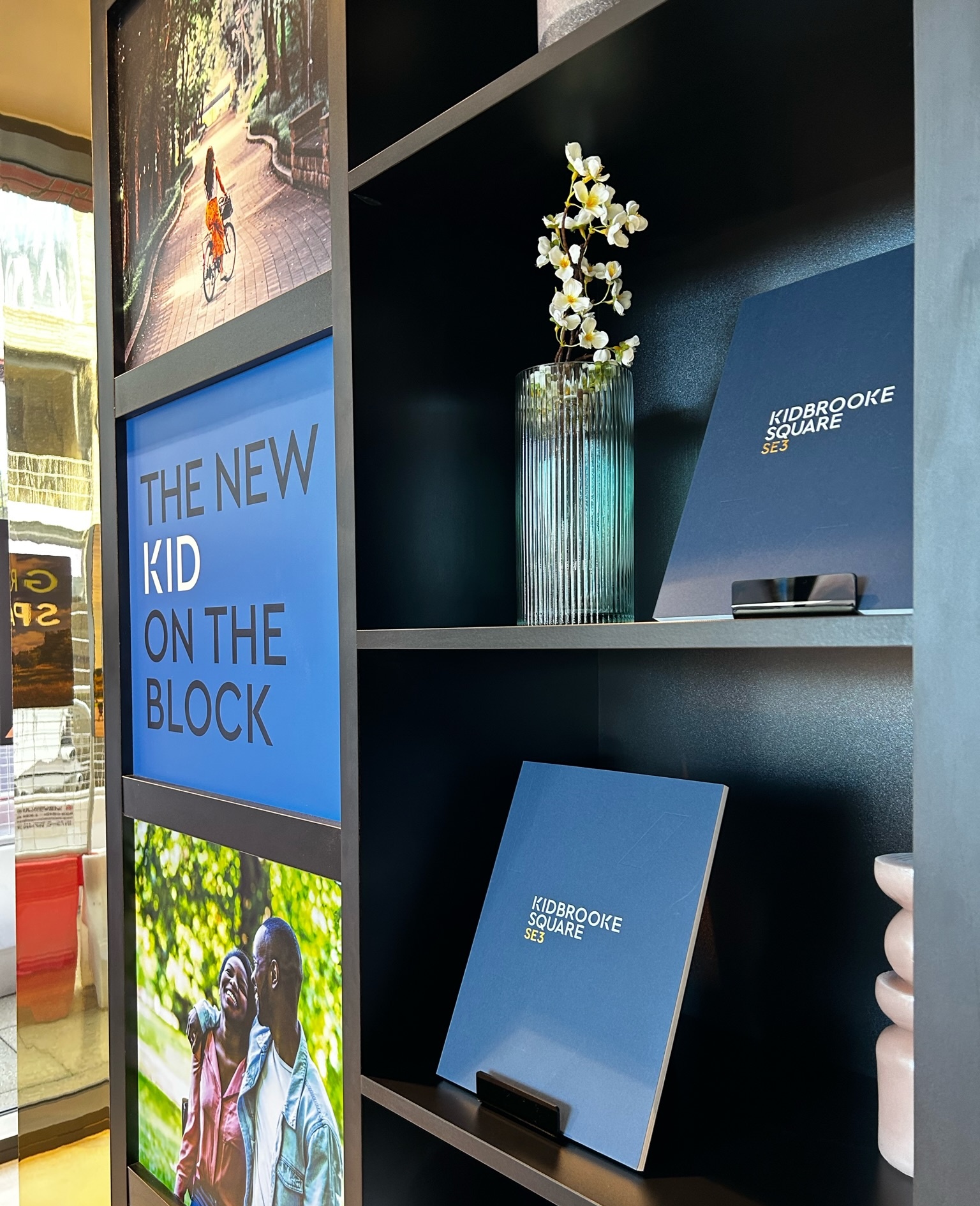 shelf with books that showcase a property development and pictures to one side of the shelf