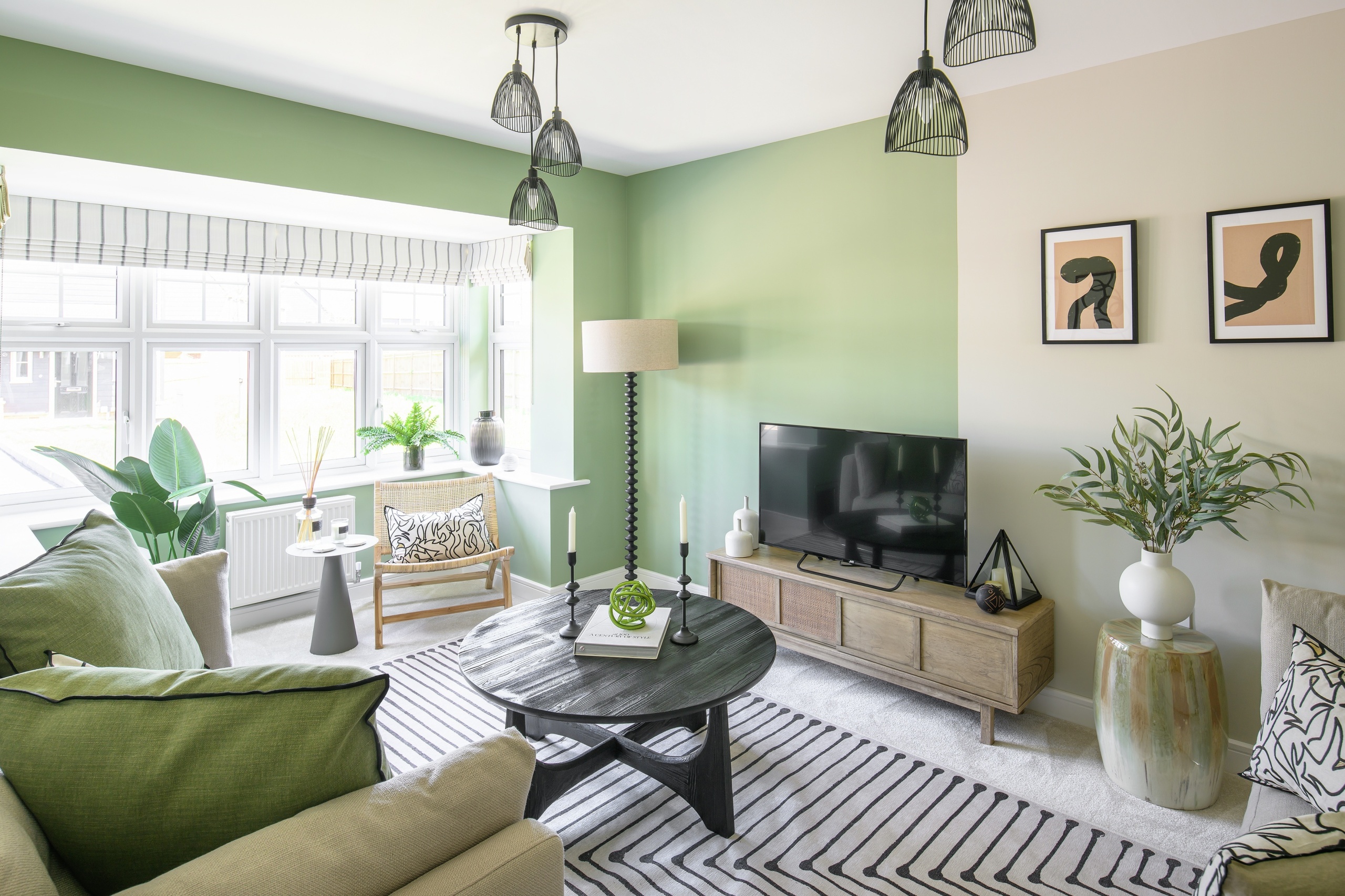 A spacious living room with lots of plants and a green colour scheme