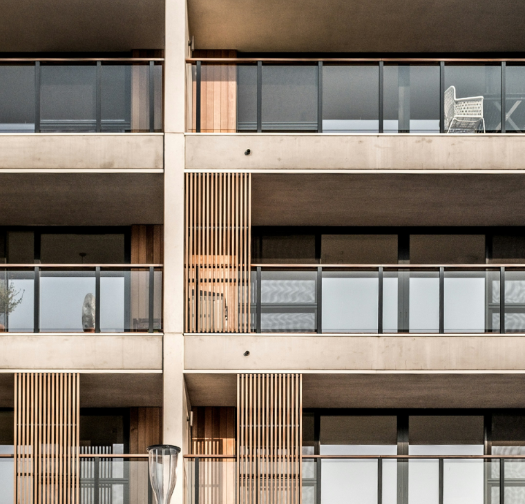 A modern apartment building with glass balconies and wooden panel accents, featuring the title 'In Focus: The Rise of Build to Rent' in bold white text against a blue overlay. A circular logo with the letter 'F' is in the upper right corner.